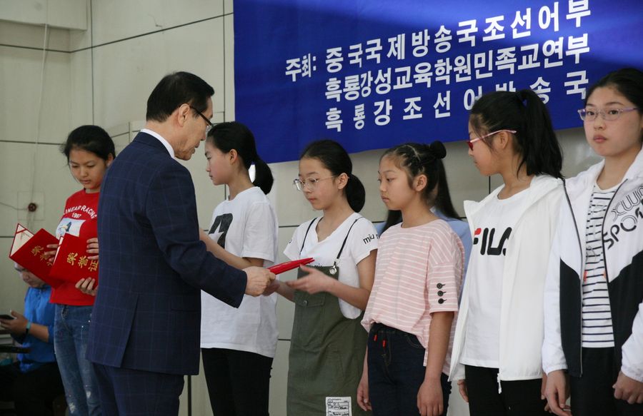 김태식 한국유나이드제약 전무가 조선족 중학생들에게 장학금과 장학증서를 전달하고 있다.