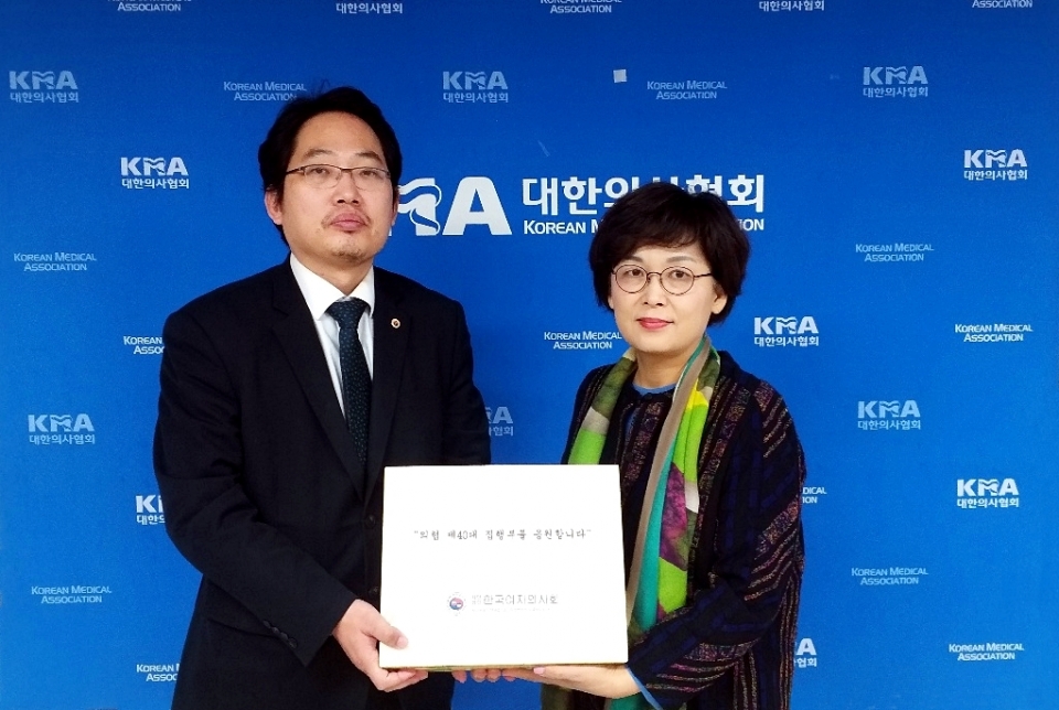 최대집 대한의사협회장에게 한국여자사회를 대신해 감사의 떡을 전달하고 있는 홍순원 한국여자의사회 국제이사(의협 대외협력이사). ⓒ의협신문