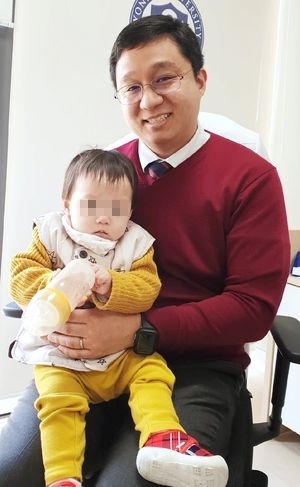 강윤구 원주연세의대 교수(원주세브란스기독병원 소아청소년과)가 희귀난치성 질환인 당원병을 앓다가 건강을 되찾은 2세 여아를 안고 있다.