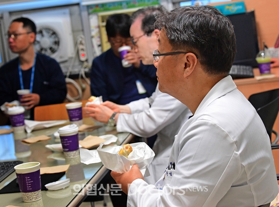 이른 아침 진행된 수부외과 컨퍼런스에 참석한 의사들이 스터디를 하면서  커피와 토스트를 먹고 있다. ⓒ의협신문 김선경
